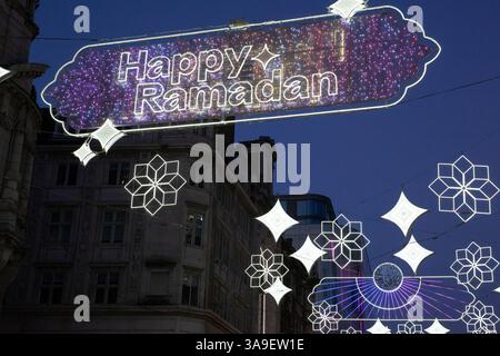London, Großbritannien. 30. März 2025. Auf der Coventry Street zwischen Leicester Square und Piccadilly Circus leuchten die dekorativen Ramadan-Lichter bei Sonnenuntergang, während Muslime auf der ganzen Welt Eid al-Fitr und das Ende ihres täglichen Fastenmonats feiern. Viele muslimische Touristen und Einheimische hielten an, um die Lichter zu fotografieren, und es gab eine festliche Atmosphäre, die durch das warme, trockene Wetter unterstützt wurde. Quelle: Anna Watson/Alamy Live News Stockfoto