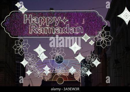 London, Großbritannien. 30. März 2025. Auf der Coventry Street zwischen Leicester Square und Piccadilly Circus leuchten die dekorativen Ramadan-Lichter bei Sonnenuntergang, während Muslime auf der ganzen Welt Eid al-Fitr und das Ende ihres täglichen Fastenmonats feiern. Viele muslimische Touristen und Einheimische hielten an, um die Lichter zu fotografieren, und es gab eine festliche Atmosphäre, die durch das warme, trockene Wetter unterstützt wurde. Quelle: Anna Watson/Alamy Live News Stockfoto