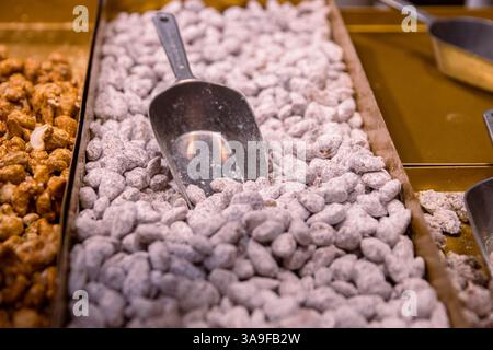 Gezuckerte Mandeln. Kandierter Zucker ummantelte karamellisierte Mandelnüsse, die auf dem Weihnachtsmarkt verkauft werden. Haufen gerösteter Süßigkeiten auf dem Metall t Stockfoto