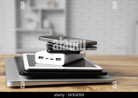 Stapel moderner Gadgets auf Holztisch in der Werkstatt Stockfoto