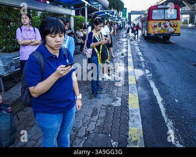 25. September 2017 - Rangsit, Pathum Thani, Thailand - Passagiere warten an einer Transitstation in der Nähe der Future Park Mall in Rangsit, Provinz Pathum Thani, etwa eine Stunde nördlich von Bangkok, an Bord von Bussen nach Bangkok. Einst eine ruhige Provinz im Reisanbaugebiet Zentralthailands, ist Pathum Thani, insbesondere Rangsit, die südlichste Stadt der Provinz, zu einem Vorort von Bangkok geworden. Zehntausende von Menschen nutzen die Bus- und Kleinbushaltestellen, um zu den Stadtbahnstationen in Bangkok zu gelangen und dann zur Arbeit zu gehen. Hunderte weitere fahren mit den State Railways of Thailand Pendlerzügen, die von den nördlichen Vororten nach Thailand fahren Stockfoto