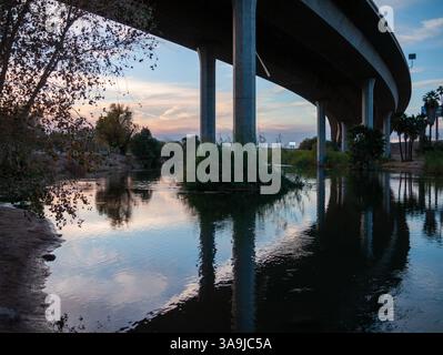 Die Brücke der Interstate 8 überspannt den Colorado River in Yuma, Arizona, und spiegelt sich während eines ruhigen Wüstenabends im Wasser. Stockfoto