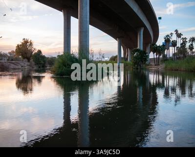Die Brücke der Interstate 8 überspannt den Colorado River in Yuma, Arizona, und spiegelt sich während eines ruhigen Wüstenabends im Wasser. Stockfoto