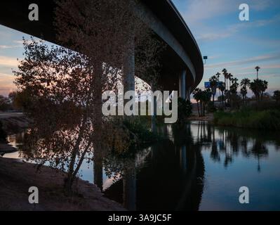 Die Brücke der Interstate 8 überspannt den Colorado River in Yuma, Arizona, und spiegelt sich während eines ruhigen Wüstenabends im Wasser. Stockfoto