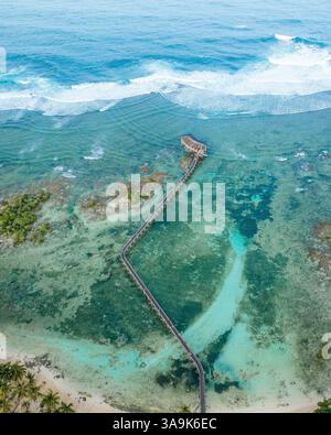 Atemberaubende Aussicht auf Cloud 9 Beach in Siargao aus der Vogelperspektive – Eine atemberaubende Strecke aus weißem Sand, türkisfarbenem Wasser und eine malerische Holzpromenade über dem Ozean Stockfoto