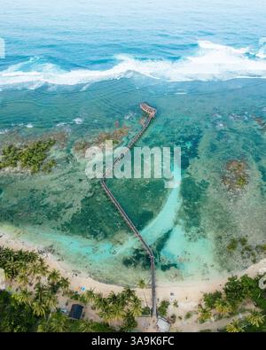 Atemberaubende Aussicht auf Cloud 9 Beach in Siargao aus der Vogelperspektive – Eine atemberaubende Strecke aus weißem Sand, türkisfarbenem Wasser und eine malerische Holzpromenade über dem Ozean Stockfoto