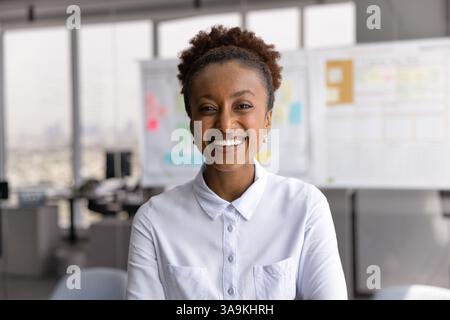 Glückliche erfolgreiche, schöne afroamerikanische Geschäftsfrau posiert für den Kopfschuss Stockfoto