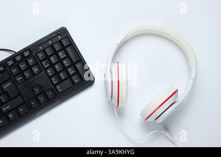 Spielgeräte. Tastatur und Kopfhörer auf weißem Hintergrund. Musikkonzept. Computerspielwettbewerb. Draufsicht Stockfoto