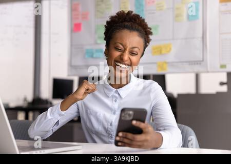 Glückliche überglücklich junge schwarze Geschäftsfrau gewinnt den Preis Stockfoto