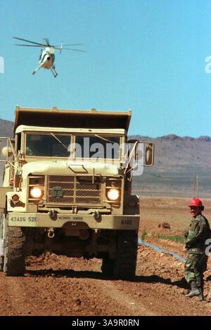 Mai 2006; Columbus, NM, USA; am 17. Mai 2006 genehmigte der US-Senat den Vorschlag, 370 Meilen dreischichtige Zäune entlang der 2.000 Meilen langen Grenze zwischen den USA und Mexiko zu bauen. DATEIFOTO: 5. März 1999. Ein Border Patrol Helikopter fliegt über eine Straßenbaumannschaft der US Army, bestehend aus Soldaten der Bravo Company, 52. Ingenieurbataillon, von ft. Carson, Colorado, arbeitet an einer Niedrigwasserüberquerung an einer Straße, die die Einheit in der Wüste an der Grenze zwischen den USA und Mexiko westlich von Columbus, New Mexico, baut, am 5. März 1999. Die Männer sind Mitglieder eines Kontigents von 128 Soldaten der US-Armee, denen vorübergehend zugewiesen wurde Stockfoto