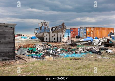 Verlassenes Fischerboot, Müll und Schiffscontainer an einem Kiesstrand (Wüste), Dungeness, Kent, England Stockfoto