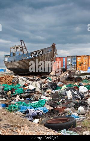 Verlassenes Fischerboot, Müll und Schiffscontainer an einem Kiesstrand (Wüste), Dungeness, Kent, England Stockfoto