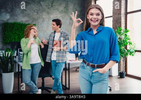 Ein vielfältiges Team arbeitet in einem hellen Bürobereich mit freundlicher Atmosphäre zusammen Stockfoto