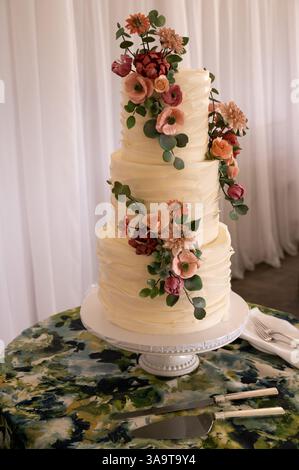 Eine atemberaubende dreistufige Hochzeitstorte mit zarten Zuckerblumen Stockfoto
