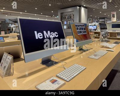 Paris, Frankreich - 3. Oktober 2023: IMac-Desktop-Modelle mit Tastaturen und Display-Bildschirmen sind auf Holztischen unter Deckenleuchten im A ordentlich angeordnet Stockfoto
