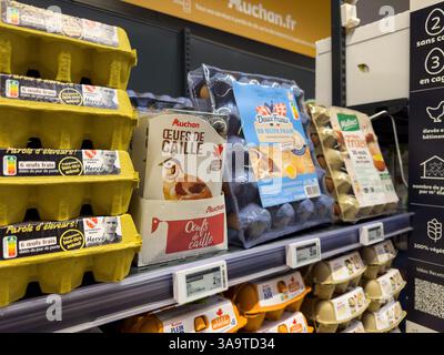 Paris, Frankreich - 14. März 2025: Verschiedene Eierschachteln, darunter Wachteleier und frische Hühnereier, werden in einem Supermarktregal in Auchan in Frankreich ausgestellt Stockfoto