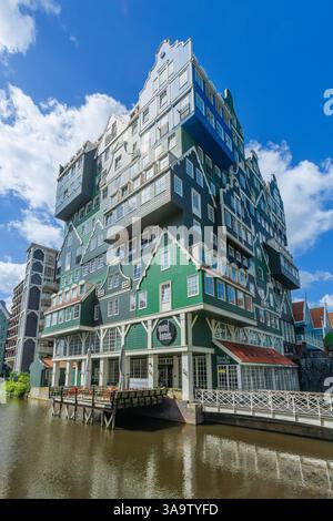 Farbenfrohes Inntel Hotel in Zaandam, übereinander gestapelte traditionelle Zaanse Häuser in Grün und Blau und Kanal davor. Stockfoto