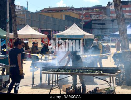 Barcelona, Spanien - 15. März 2025: Traditionelles Barbecue in Barcelona mit Menschen, die Kalksteine auf einem Markt im Freien grillen Stockfoto