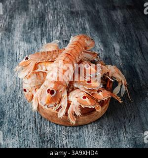 Nahaufnahme einiger Squilla Mantis, einer Art von Mantis Shrimps, die auf spanisch galeras genannt wird, auf einem grauen Holztisch Stockfoto