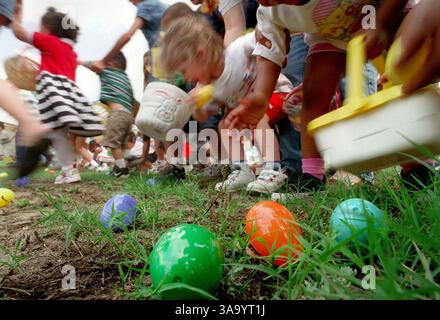 April 1999; San Antonio, TX, USA; Kinder beeilen sich, Ostereier während einer Ostereierjagd im Brooks AFB zu holen. Teenager aus dem Teenagerzentrum in Brooks haben die Veranstaltung gesponsert. Stockfoto