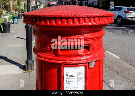 Traditionelle rote kreisförmige Viktorianischer Briefkasten in einem Wohnviertel im Norden von London, Großbritannien Stockfoto