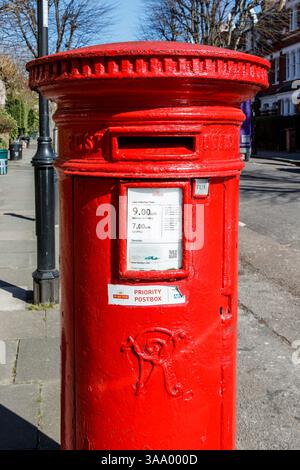 Traditionelle rote kreisförmige Viktorianischer Briefkasten in einem Wohnviertel im Norden von London, Großbritannien Stockfoto