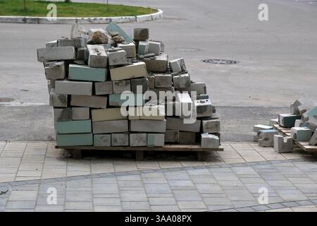 Ein Stapel von verschiedenen Ziegeln auf Paletten, in verschiedenen Farben, im Freien, Konzept der Baumaterialien Stockfoto
