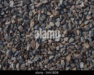 Nahaufnahme von oben auf detaillierte Textur Kies und zerquetschte Steine, natürliche Hintergründe, raue Oberfläche. Baumaterial für Bauzwecke, Grundstücke Stockfoto