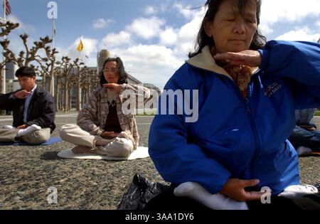Suchen Zhang (cq), 60, Rechtsextremer praktiziert Falun Gong, eine alte Praxis für Geist und Körper, die ihren Ursprung in China hat. Sie wurde hier am Mittwoch, den 10. April 2002 auf dem Civic Center Plaza in San Francisco, CA. Gezeigt. Falun Gong ist eine spirituelle Praxis, die Übungen und die Prinzipien der Wahrheit, des Mitgefühls und der Toleranz lehrt. Diese alte Praxis ist in China verboten, da viele derzeit verhaftet werden, die in China praktizieren. Ganz links sind Alan Huang (cq), 40, und Sheung Ma (cq), 52, die ebenfalls Falun Gong praktizieren. (Sacramento Bee/Jose M. Osorio) ID 7428 die Sacramento Bee/ZUMA Press Stockfoto