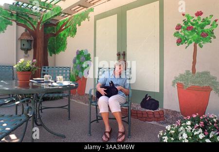 Mary Lawrence entspannt sich im temporären Essbereich neben der provisorischen Küche im Hinterhof ihres Hauses in Sacramento, während das Haus renoviert wird, Dienstag, den 4. September 2001. Die Familie renoviert die Küche und das Familienzimmer und fügt eine Garage hinzu. Sie bauten eine provisorische Mauer, die entlang der Rückseite des Hauses verläuft und die Konstruktion verdeckt. Sie hält Bob, das Kaninchen, fest, das auch an der Wand abgebildet ist. (Sacramento Bee/Leilani Hu) /ZUMA Press Stockfoto
