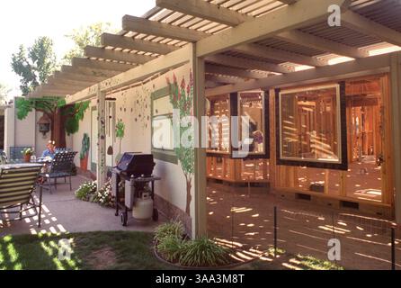 Mary Lawrence entspannt sich im temporären Essbereich im Hinterhof ihres Hauses in Sacramento, während das Haus renoviert wird, Dienstag, den 4. September 2001. Die Familie renoviert die Küche und das Familienzimmer und fügt eine Garage hinzu. Sie bauten eine provisorische Mauer, die entlang der Rückseite des Hauses verläuft und die Konstruktion verdeckt. (Sacramento Bee/Leilani Hu) /ZUMA Press Stockfoto