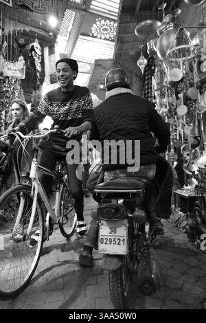 Januar 2025 - Eine Straßenszene auf dem Markt/Souks von Marrakesch, Marokko mit Händlern und Passanten. Reportage-Stil in Schwarz und weiß Stockfoto