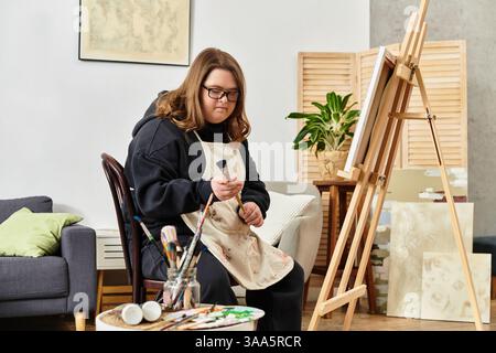 In einer gemütlichen Umgebung zeigt eine selbstbewusste junge Frau mit Down-Syndrom ihr künstlerisches Talent. Stockfoto