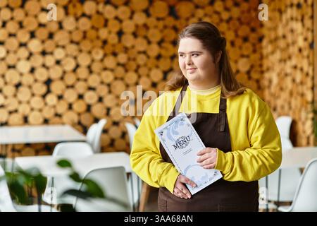 Eine junge Frau mit Down-Syndrom zeigt selbstbewusst das Menü in einem lebhaften Café. Stockfoto