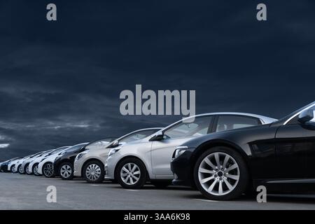 Autos vor dramatischem Himmel. Ein Symbol der Krise in der Automobilindustrie. Stockfoto