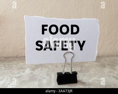 Lebensmittelsicherheitsnachricht auf gerissenem weißem Papierstück auf Wandhintergrund geschrieben. Begriffliches Symbol für Lebensmittelsicherheit. Kopierbereich. Stockfoto