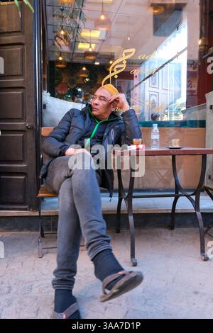 DEC30 2024 - Marrakesch, Marokko - Ein einheimischer Mann wartet in einem Café in der alten Medina von Marrakesch in einem Café mit Kaffee und Zigaretten Stockfoto