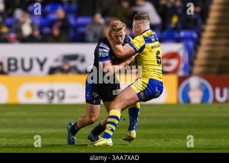 WARRINGTON, ENGLAND - 28. MÄRZ 2025: Lachie Miller aus Leeds Rhinos wird während der Betfred Super League von George Williams von Warrington Wolves bekämpft Stockfoto