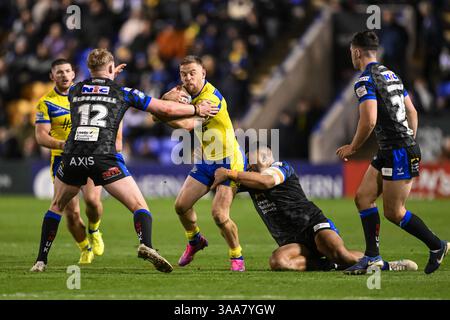 WARRINGTON, ENGLAND – 28. MÄRZ 2025: Matt Dufty von Warrington Wolves wird während der Betfred Super League Rou von Keenan Palasia aus Leeds Rhinos angegriffen Stockfoto