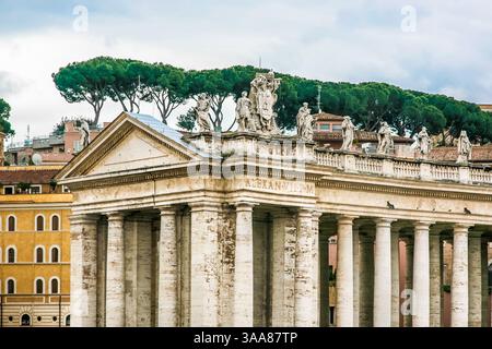 Ein großes Gebäude St. Peter Kirche des Vatikans in Italien mit einer blauen Kuppel und einem Kreuz auf der Spitze. Auf dem Gebäude befinden sich viele Statuen Stockfoto