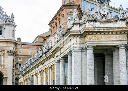 Ein großes Gebäude St. Peter Kirche des Vatikans in Italien mit einer blauen Kuppel und einem Kreuz auf der Spitze. Auf dem Gebäude befinden sich viele Statuen Stockfoto