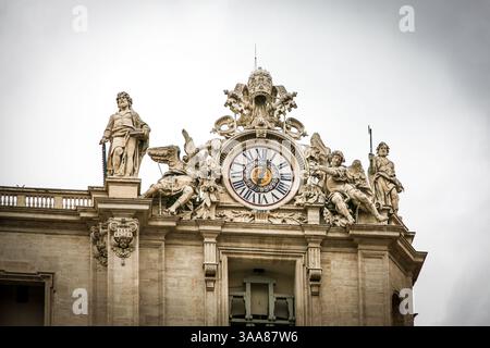 Ein großes Gebäude St. Peter Kirche des Vatikans in Italien mit einer blauen Kuppel und einem Kreuz auf der Spitze. Auf dem Gebäude befinden sich viele Statuen Stockfoto