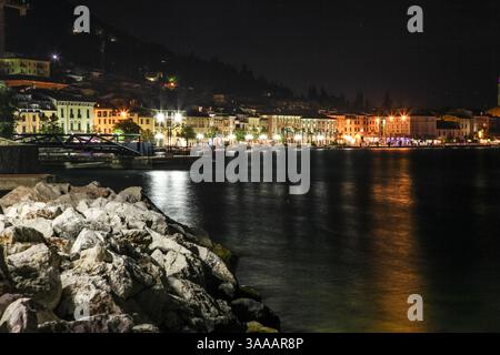 Eine Stadt Salo in Italien am Gardasee mit einem großen Gewässer im Hintergrund. Das Wasser ist dunkel und die Stadt ist nachts beleuchtet Stockfoto