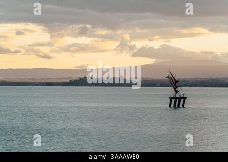 Ein großer Wasserkörper, auf dem die Sonne scheint. Die Sonne ist am Himmel und das Wasser ist ruhig. Ein Abend auf dem Trasimeno-See in der Region Umbrien Ital Stockfoto