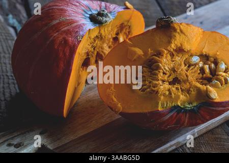 Schneiden Sie den Winter-Kürbis mit halbem orangefarbenem Buttercup auf dem Schneidebrett Stockfoto