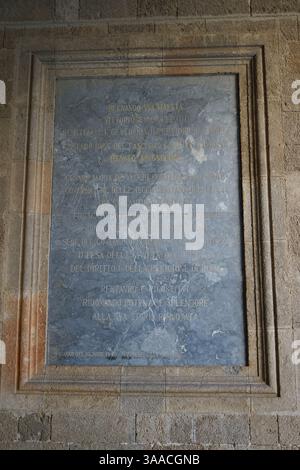 Steintafel mit einer lateinischen Inschrift an der Innenwand des Palastes des Großmeisters der Ritter von Rhodos, Griechenland. Vertikales Bild. Stockfoto