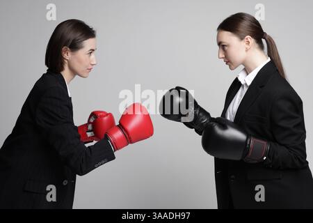 Wettbewerb. Geschäftsfrauen im Handschuhboxen auf grauem Hintergrund Stockfoto