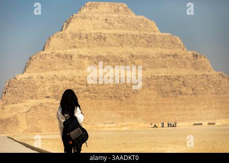 Kairo, Ägypten; 20. Januar 2024: Folgen Sie einem Touristen, der die Zoser-Pyramide in Sakkara, Memphis, Ägypten, erkunden Sie, eine antike Stätte von pharaonischer Bedeutung. Stockfoto