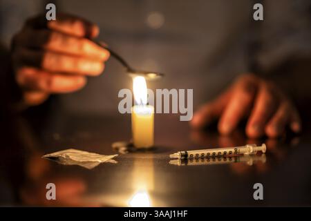 Spritze, Kerze und Heldin eines Junkies Stockfoto