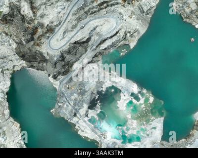 Tagebauindustrie. Kalksteinbruch mit Baggerlader und Lkw in Betrieb. Schwermaschinen im Bergbau und Baustoffversorgung. Stockfoto